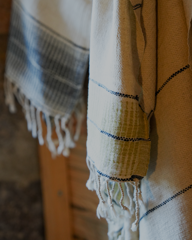 Towel with striped pattern and fringes on a wooden surface