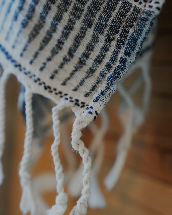 Close-up of a textured towel with fringes on a blurred background