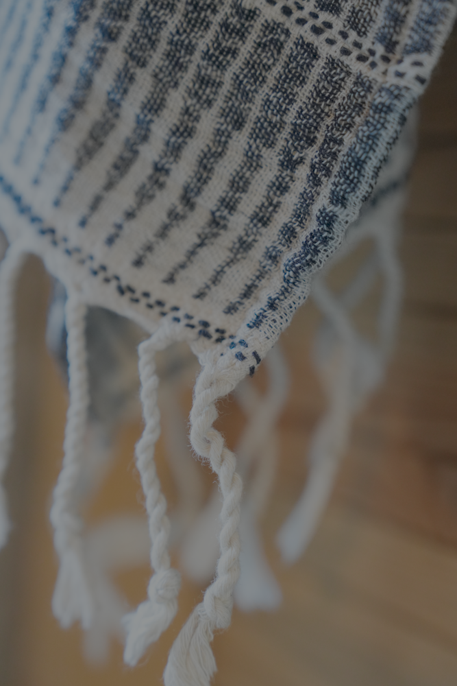Close-up of a textured towel with fringes on a blurred background