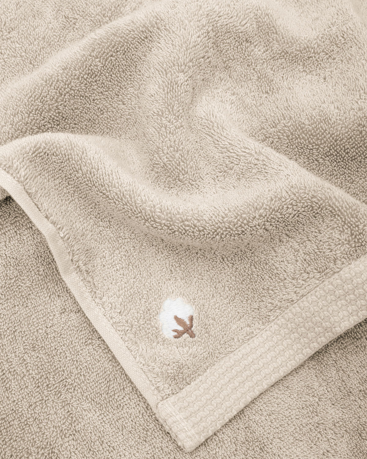 Close-up of Jasper 600-gram organic Aegean cotton luxury bath, hand, and washcloth towels in Vanilla Embrace, showcasing soft plush texture, warm tone, and luxurious fabric