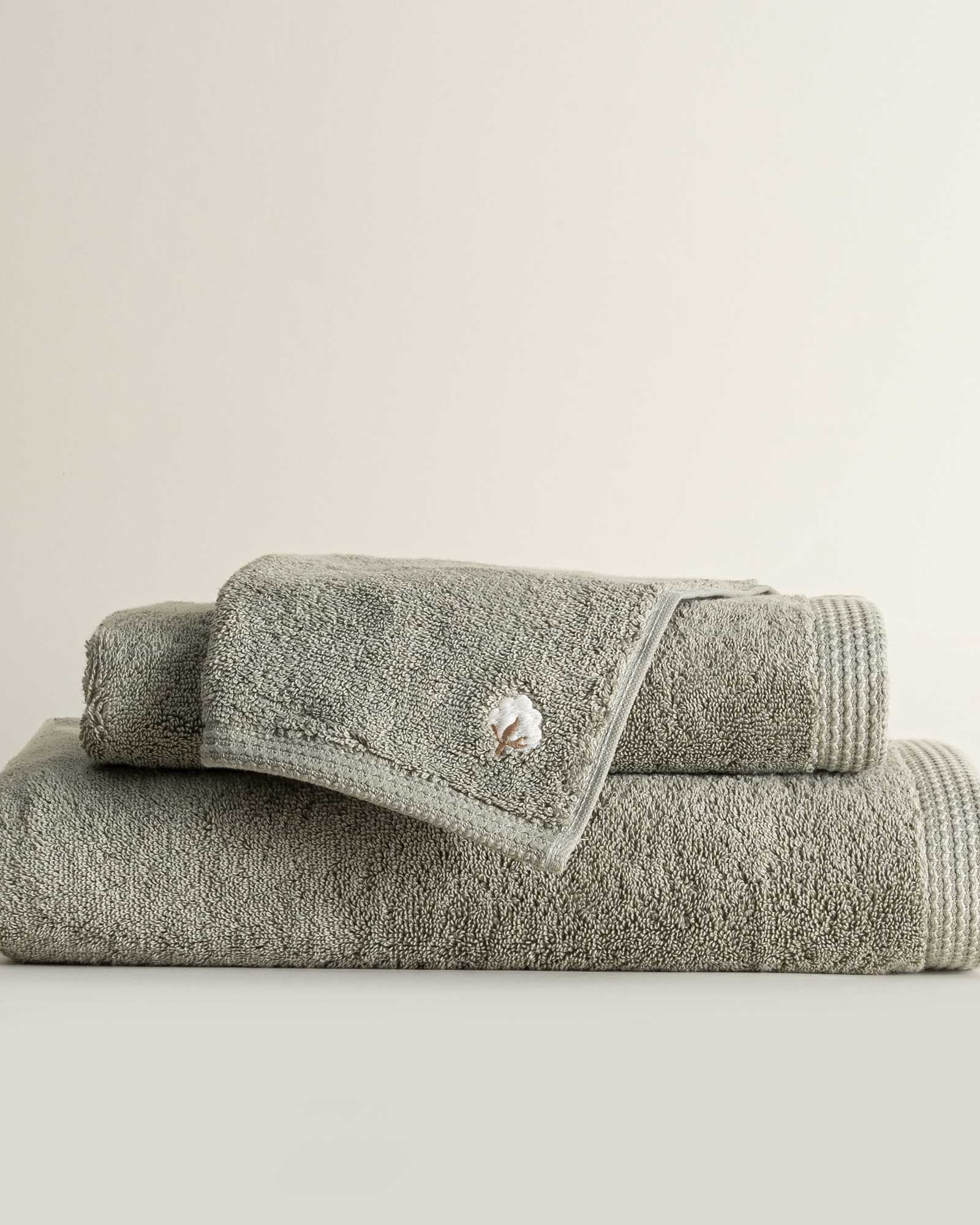 Three folded Jasper 600-gram organic Aegean cotton luxury bath, hand, and washcloth towels in Mossy Muse, showcasing soft plush texture, earthy tone, and luxurious fabric