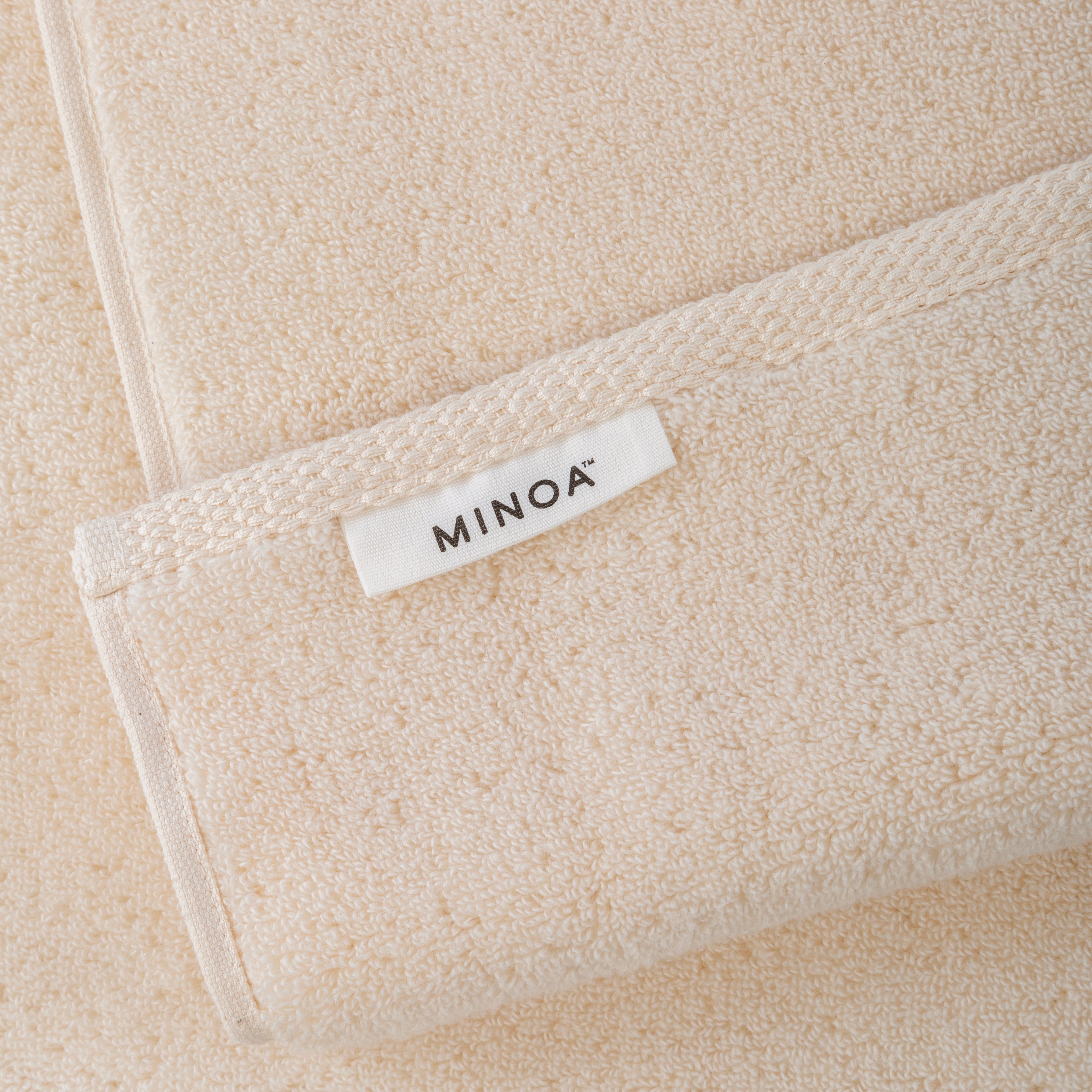 Close-up of a beige towels with a 'MINOA' label.
