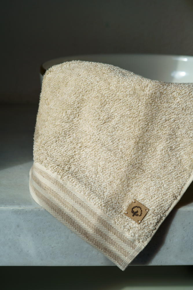 Beige towel with a brand logo on a metallic surface