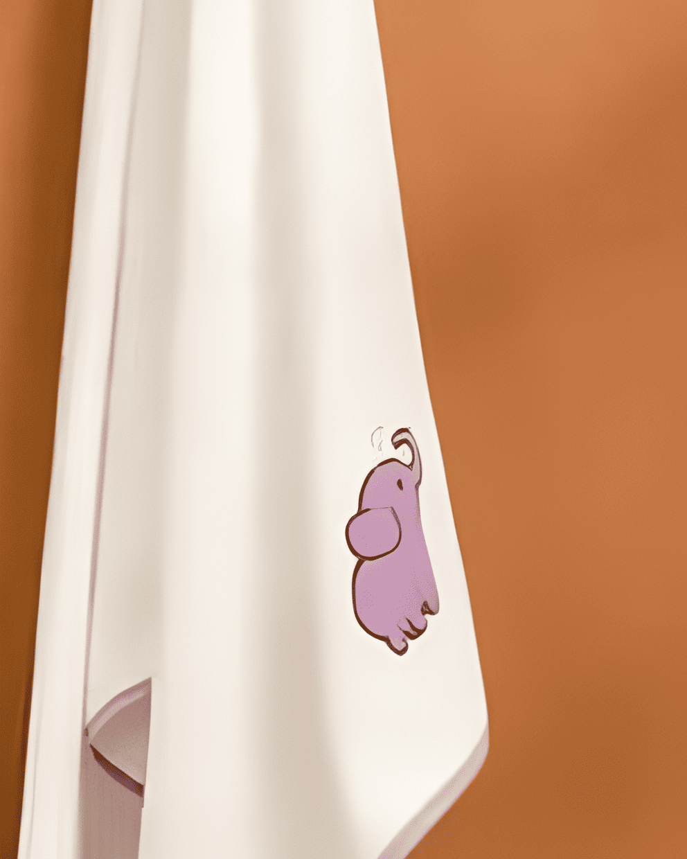 White towel with a purple elephant character on a brown background