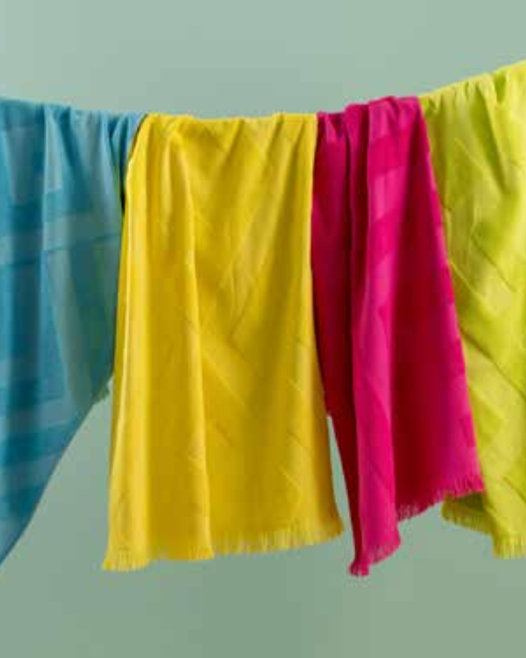 Four pieces of PESHTEMAL Maris Towel hanging on a clothes line (blue, yellow, pink, green from left to right)