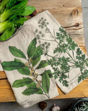Two fabric towels with botanical designs on a wooden surface.
