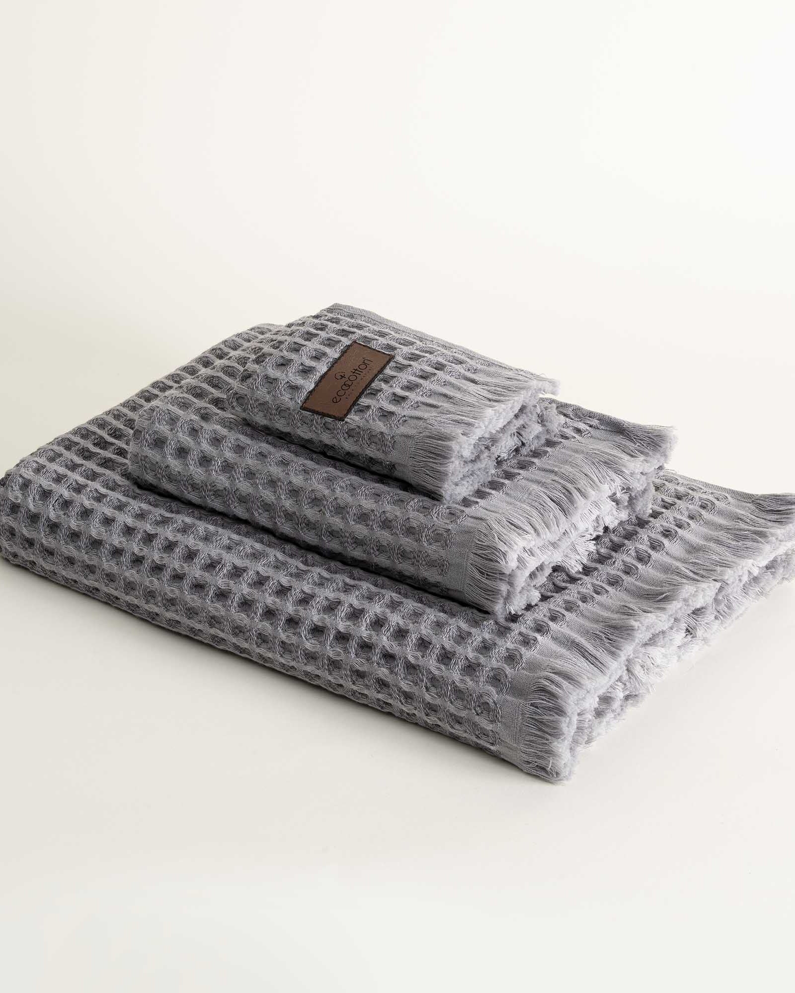 Three-piece Silver Delight Seren Organic Cotton Waffle Bath Set, including bath towel, hand towel, and washcloth, gently arranged to highlight its soft texture and natural, eco-friendly design