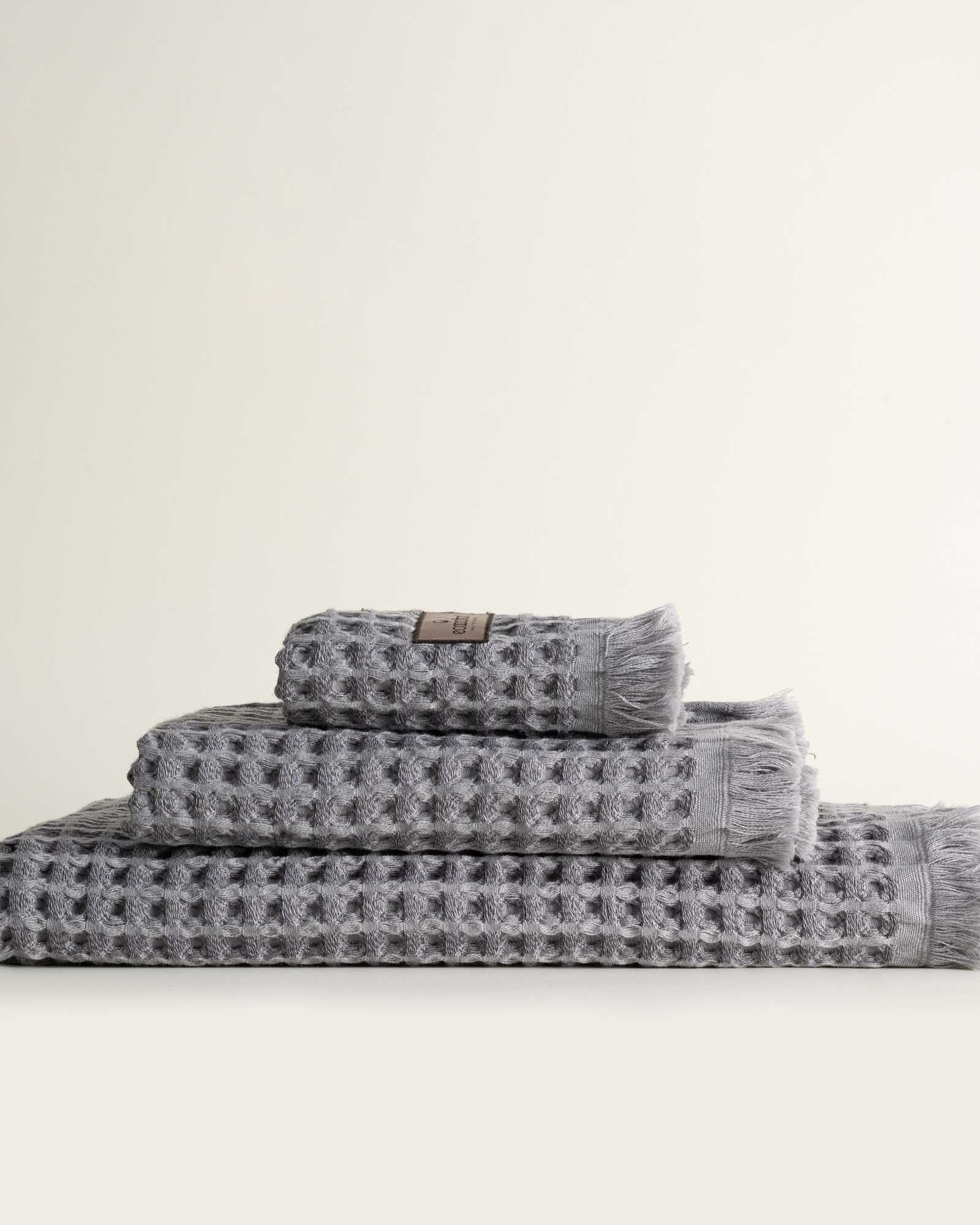 Three-piece Silver Delight Seren Organic Cotton Waffle Bath Set, including bath towel, hand towel, and washcloth, gently arranged to highlight its soft texture and natural, eco-friendly design.