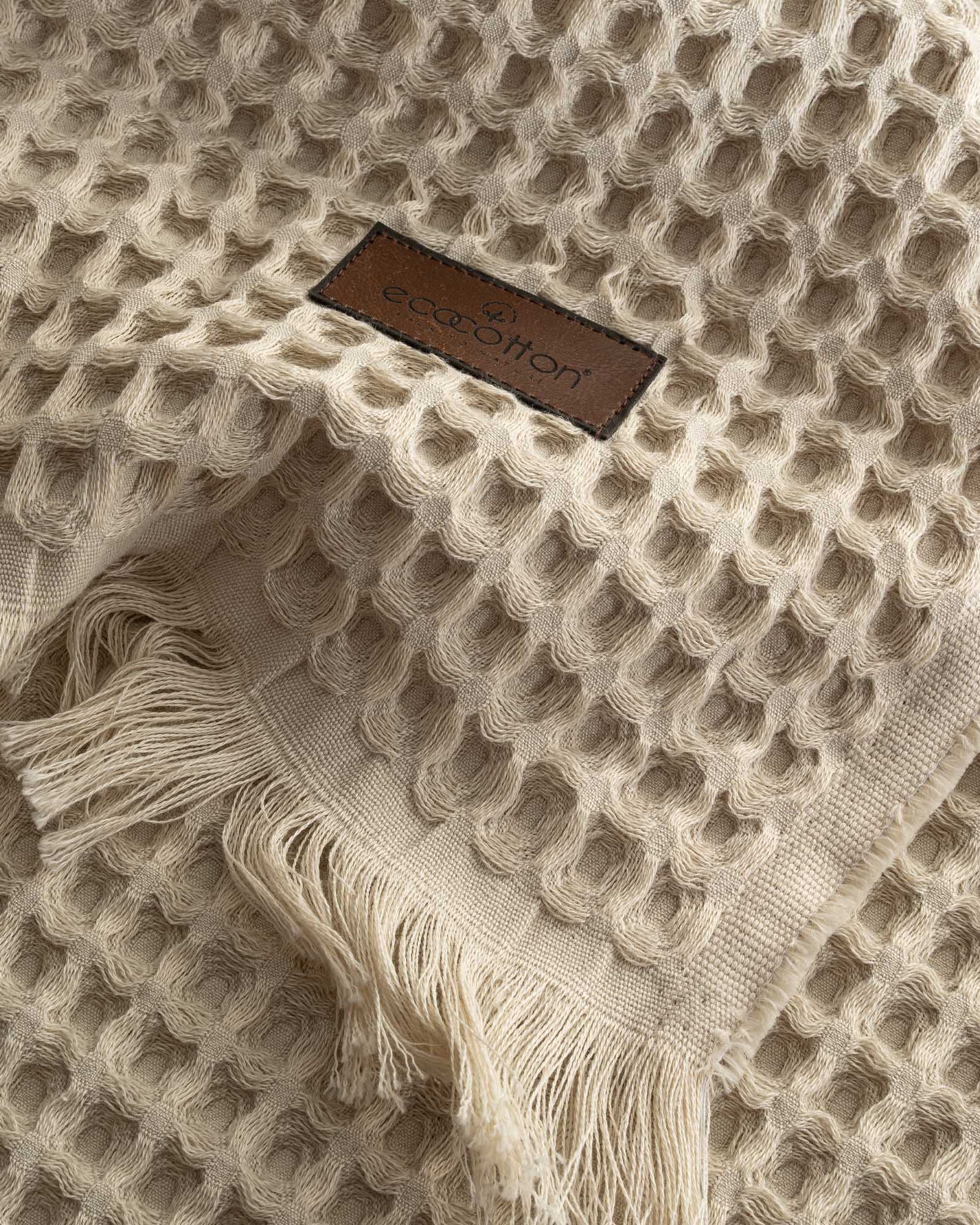 Close-up of Ecocotton tag on beige Organic Aegean Seren Waffle Large Throw/Bed Spread 400-gram, emphasizing its eco-friendly certification and premium organic cotton quality