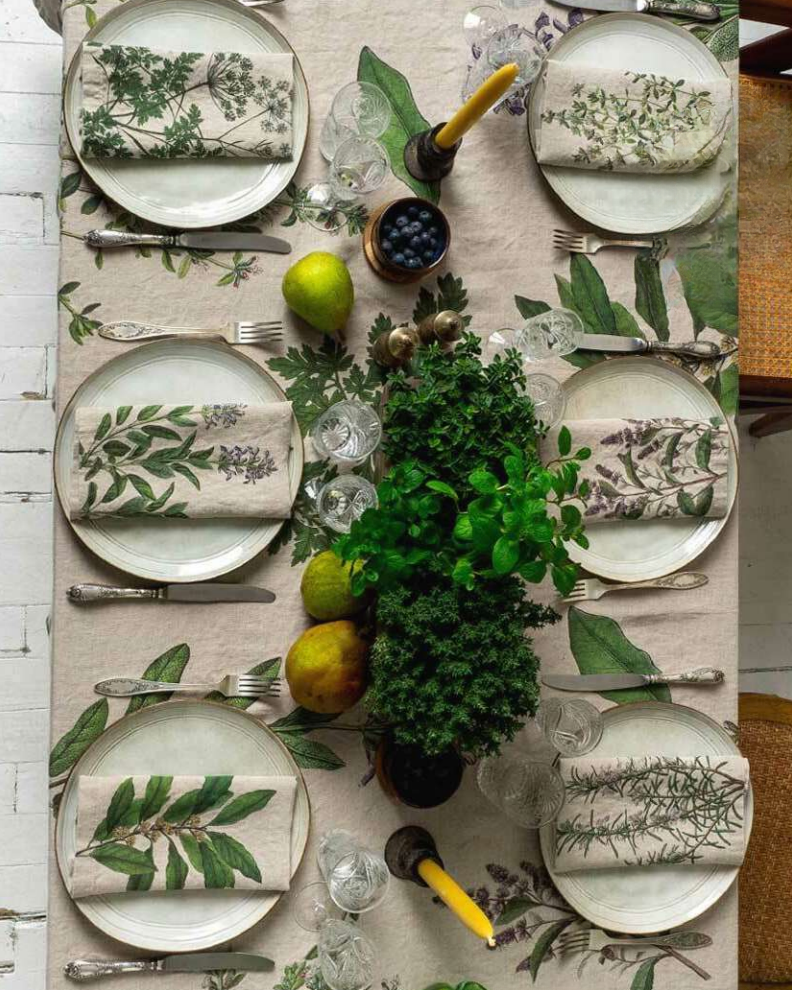 Elegant table setting with floral-patterned plates and napkins on a matching tablecloth.
