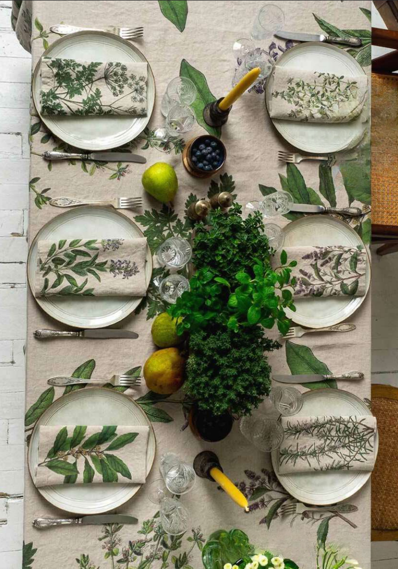 Elegant table setting with floral-patterned plates and napkins on a matching tablecloth.