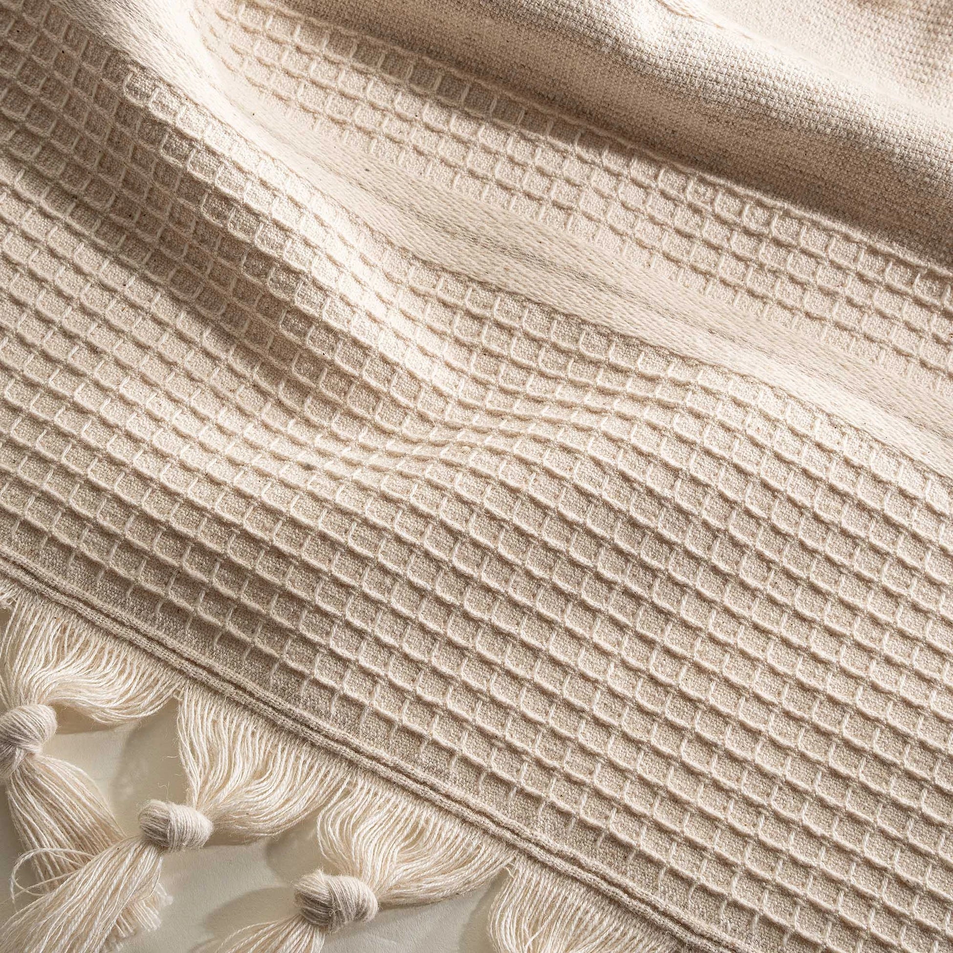 Close up of the Arden Hemp and Organic Cotton Bath Towel with tassels in sand and white showing the soft texture natural color and intricate tassel details of this luxury bath towel and organic bath towel