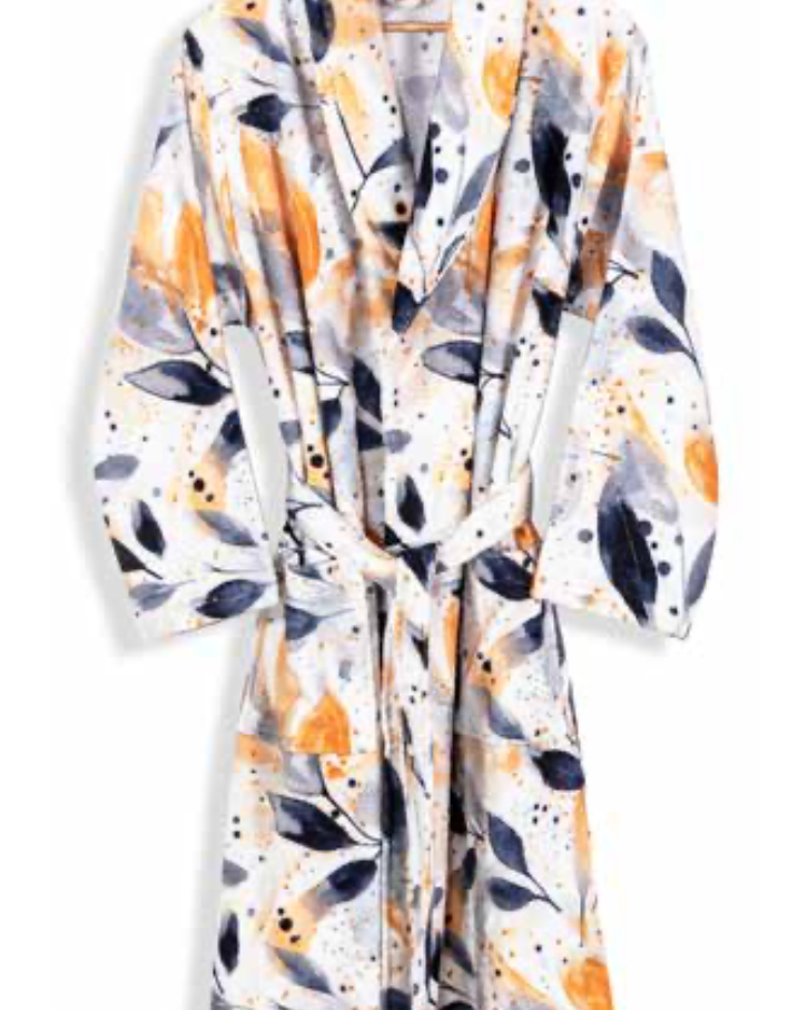 White bathrobe with abstract leaf and splatter pattern in yellow, grey, and black — modern eco-conscious home textile design.