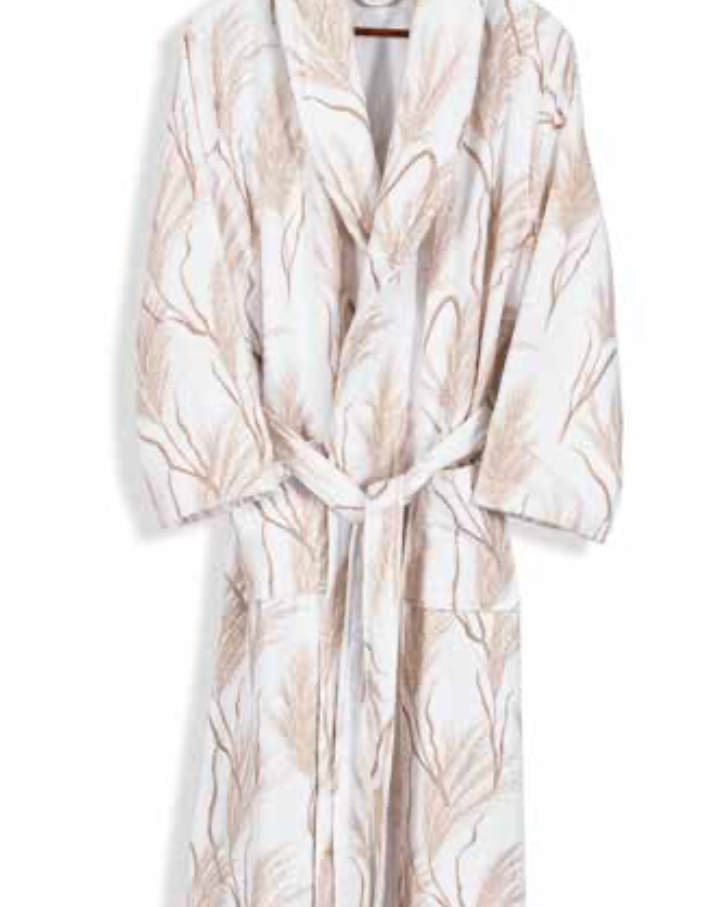 White bathrobe with soft beige leaf pattern hanging on wooden hanger — serene sustainable home textile with nature-inspired design.
