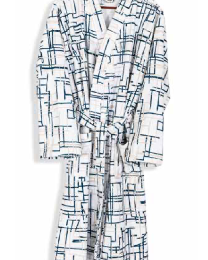 White bathrobe with modern navy geometric line pattern hanging on wooden hanger — minimalist sustainable luxury homewear.