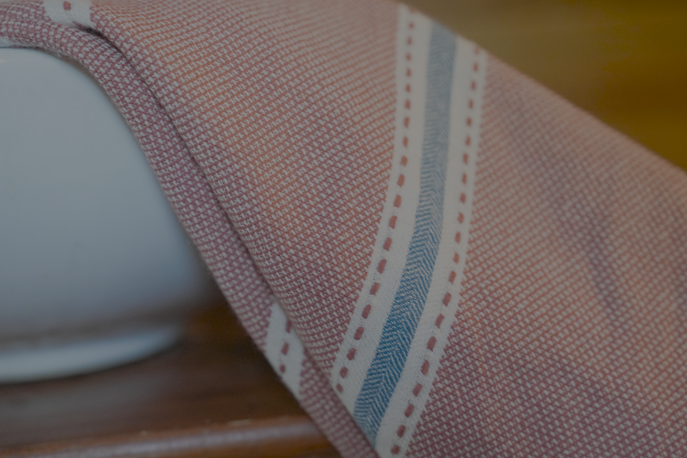 Close-up view of hazelnut colored Tulum 200 gram Aegean Cotton and Linen Turkish towel showing fine handwoven cotton texture and blue white stripes by Minoa Home highlighting the softness and quality of an organic bath towel