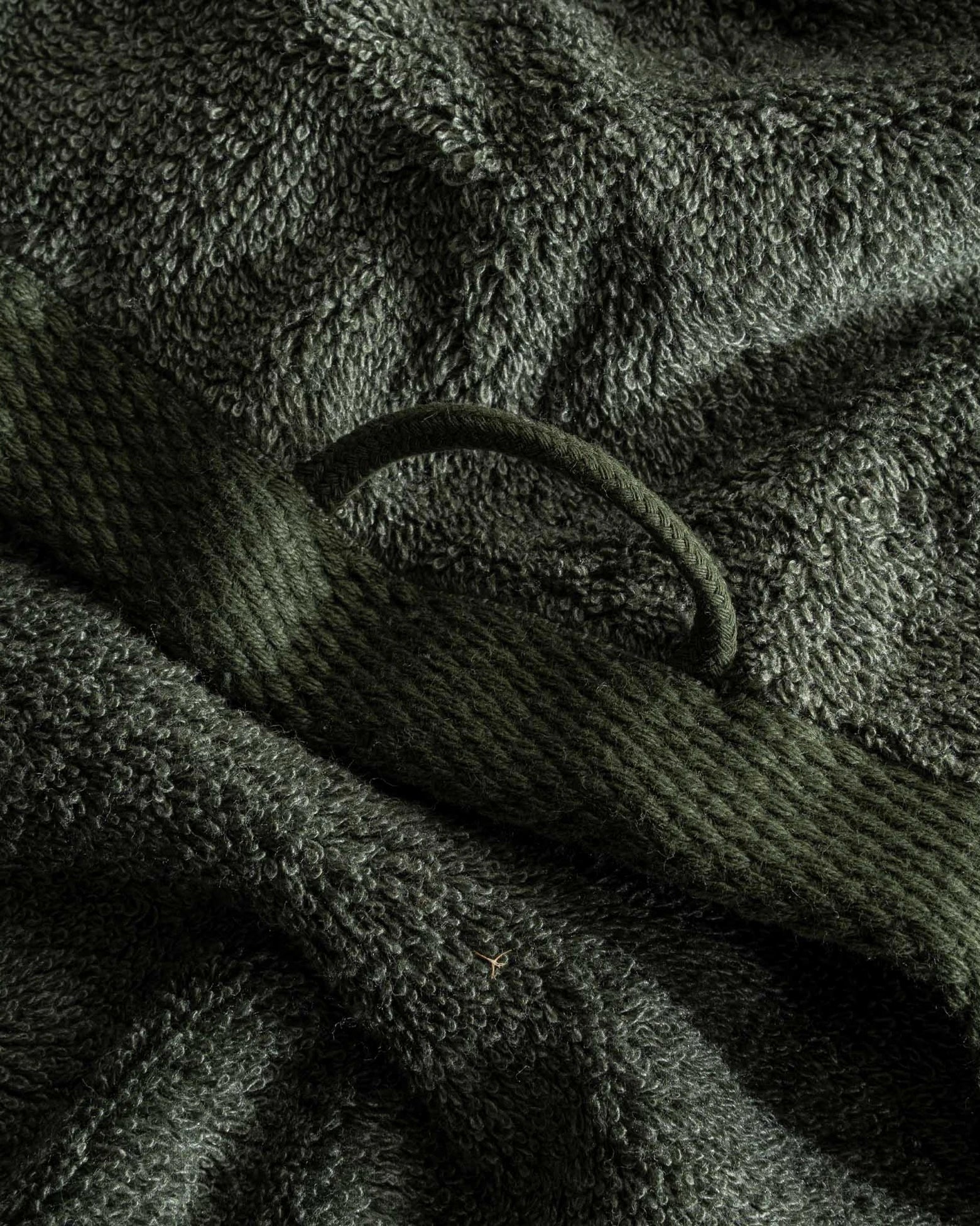Close-up of the Naia & Cotton luxury Hand Towel in Mossy Muse, highlighting its soft texture, rich colour, and luxurious fabric, with a round loop for hanging
