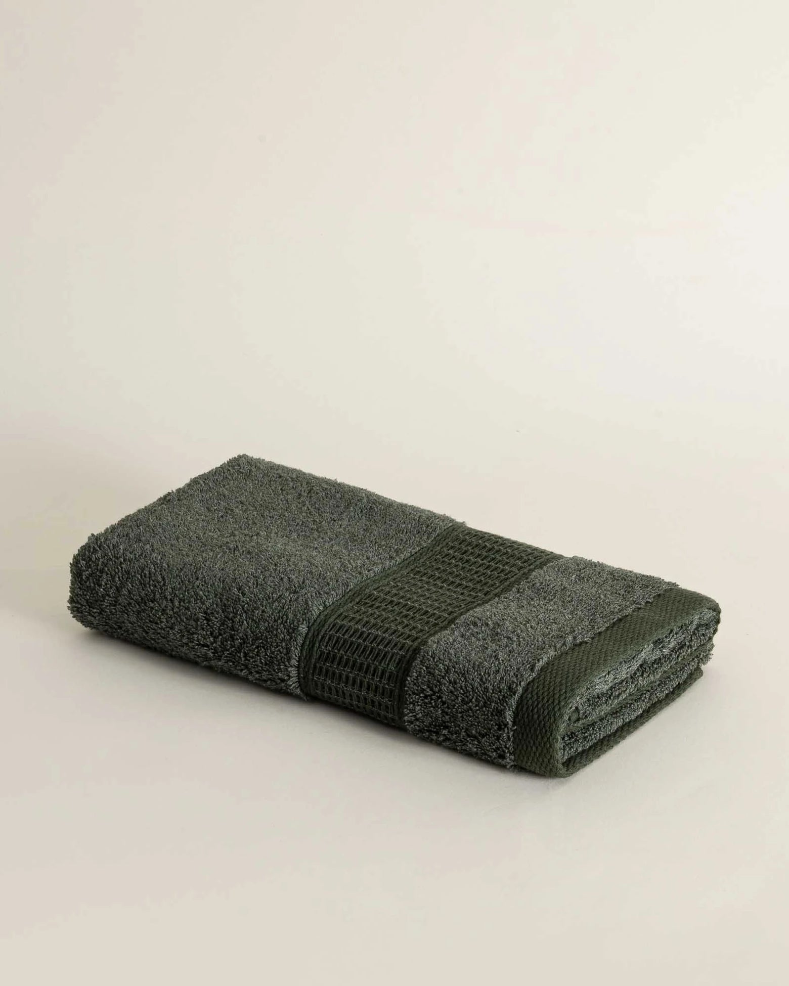 Folded Naia & Cotton luxury Hand Towel in Mossy Muse, showcasing its soft texture, elegant colour, and luxurious fabric