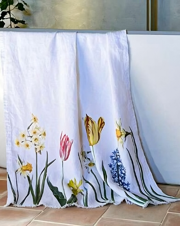 Floral-patterned towel draped over a white bathtub in a bathroom setting.