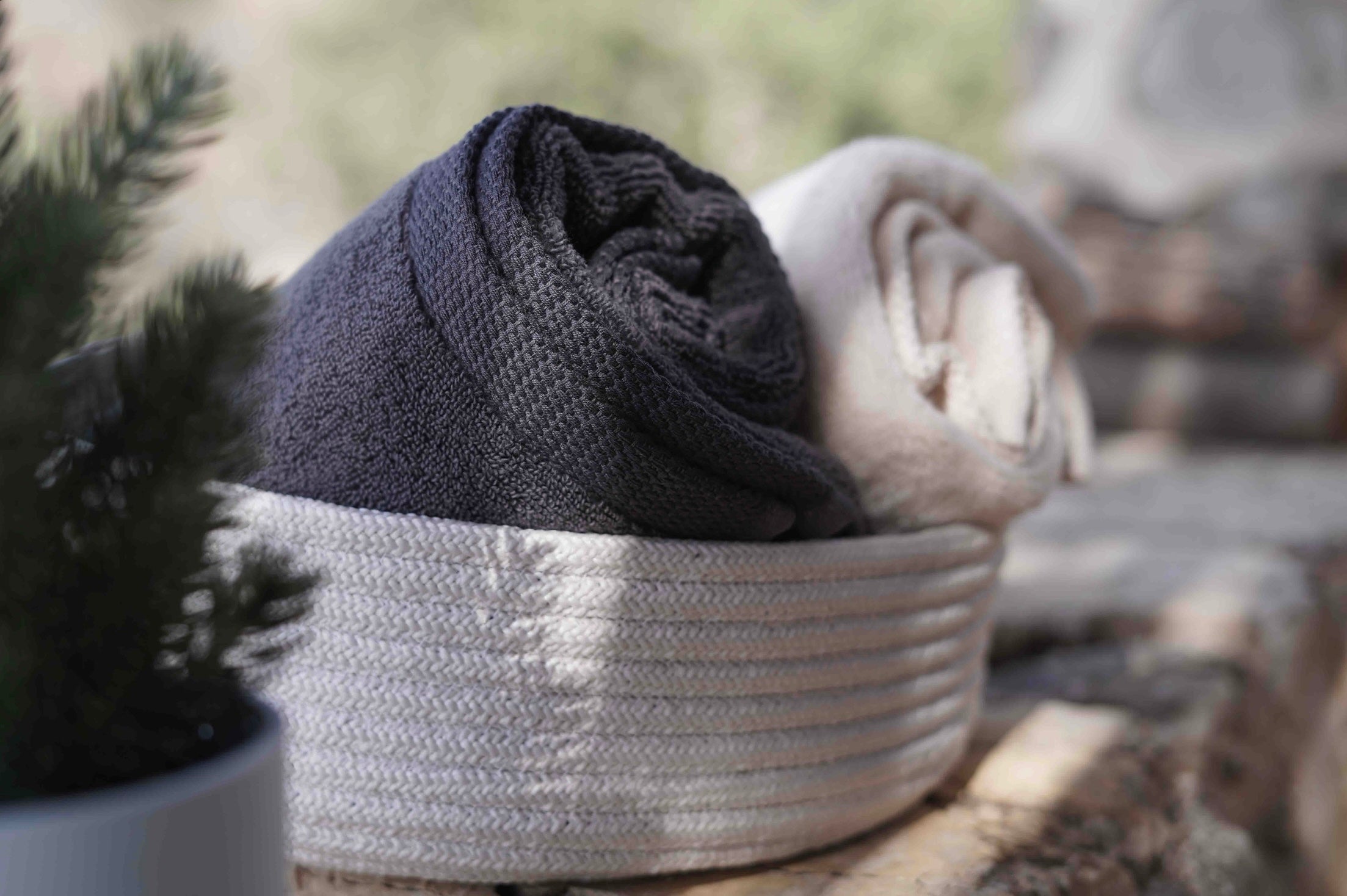 Two minoa towels in a basket (left black, right white)