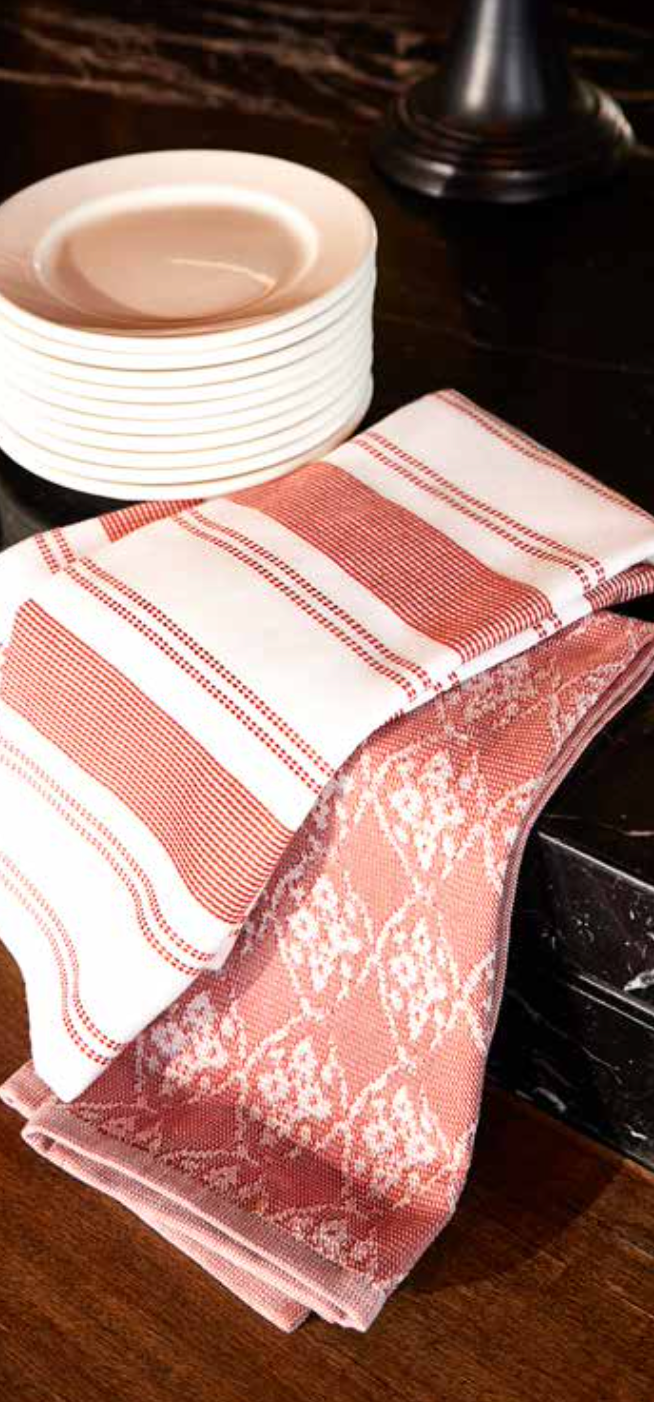 Kitchen Towel - Viva in red, placed on the kitchen table, featuring a soft, absorbent cotton design for practical use and a pop of colour