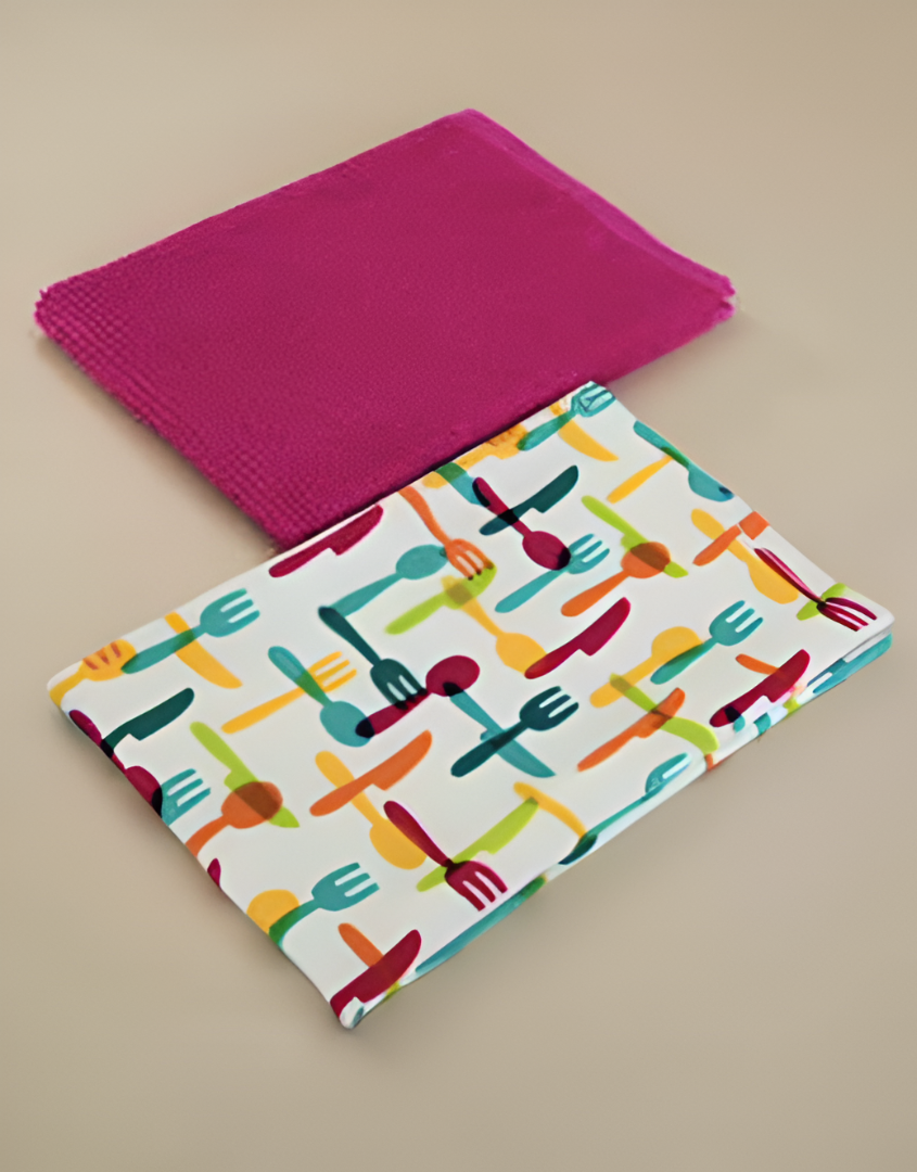 Colourful kitchen towel with cutlery pattern and pink napkin on a beige background