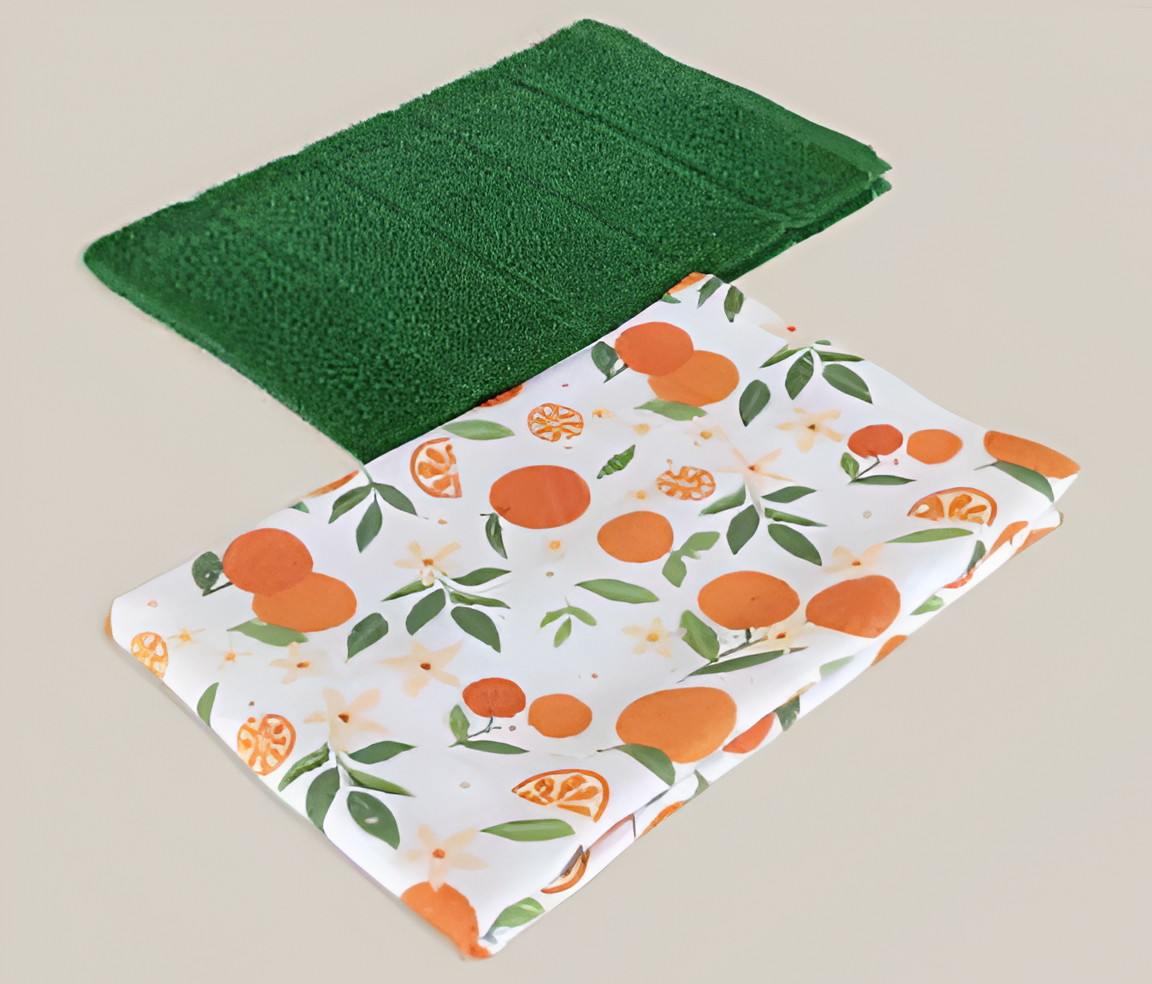 Green kitchen towel and one kitchen towel with orange pattern on a beige background