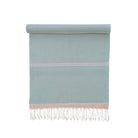 Light blue towel with white stripes and fringes on a white background