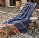 Blue towel draped over a lounge chair on a patterned patio