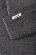 Dark gray towel with Minoa logo on a matching background