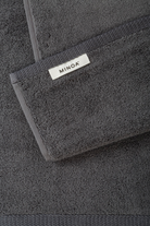 Dark gray towel with Minoa logo on a matching background