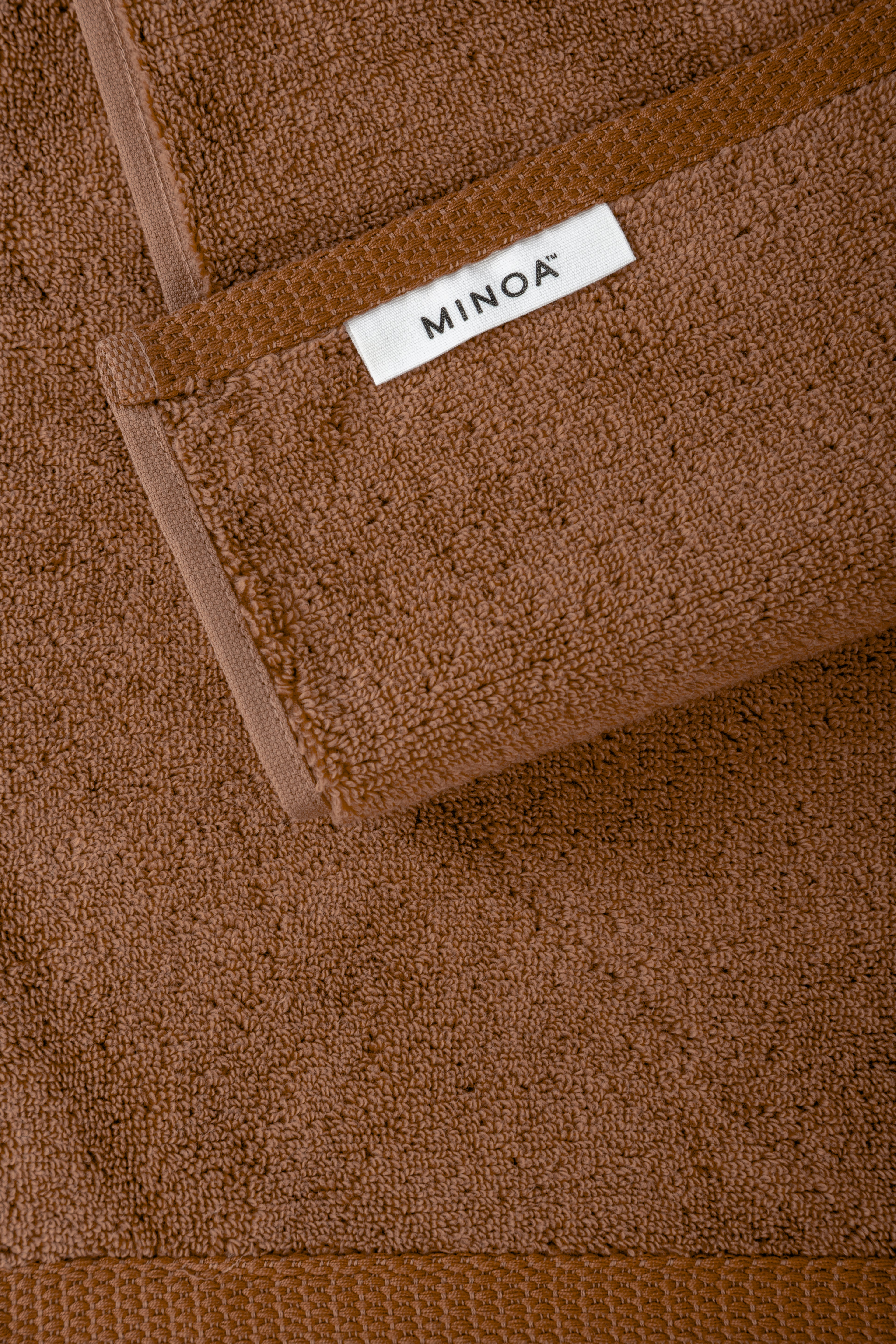 Brown towel with a visible 'MINOA' label