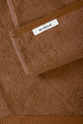 Brown towel with a visible 'MINOA' label