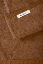 Brown towel with a visible 'MINOA' label