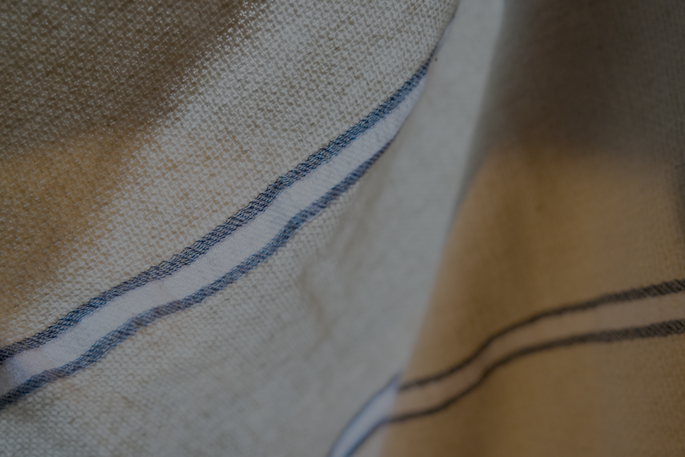 Close up of blue and white Anakao 215 gram Aegean Cotton and Linen Turkish towel showcasing its soft texture and quality as an organic bath towel