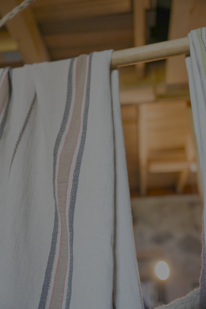 Organic bath towel from the luxury Elba Turkish collection hanging on a cloth hanger in a room
