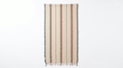 A vertical rectangular beige woven towel featuring thick sage green and thin rust-orange vertical stripes, finished with braided fringe along the bottom hem.