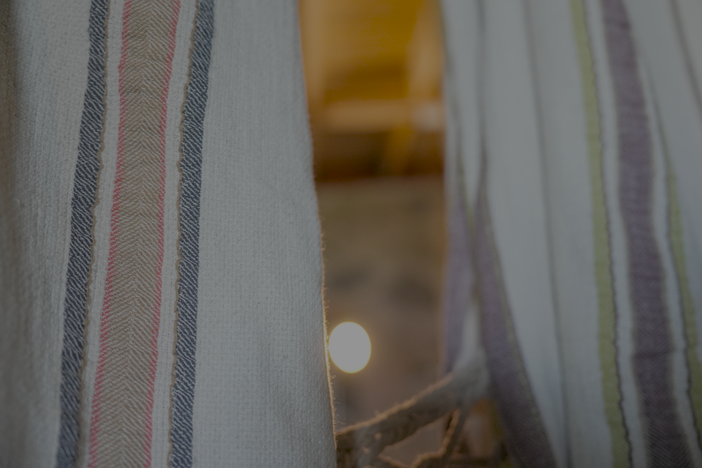 Two luxury organic Elba Turkish towels supporting circular economy hanging on a cloth hanger
