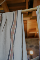 Organic bath towel from the luxury Elba Turkish collection hanging on a cloth hanger in a room
