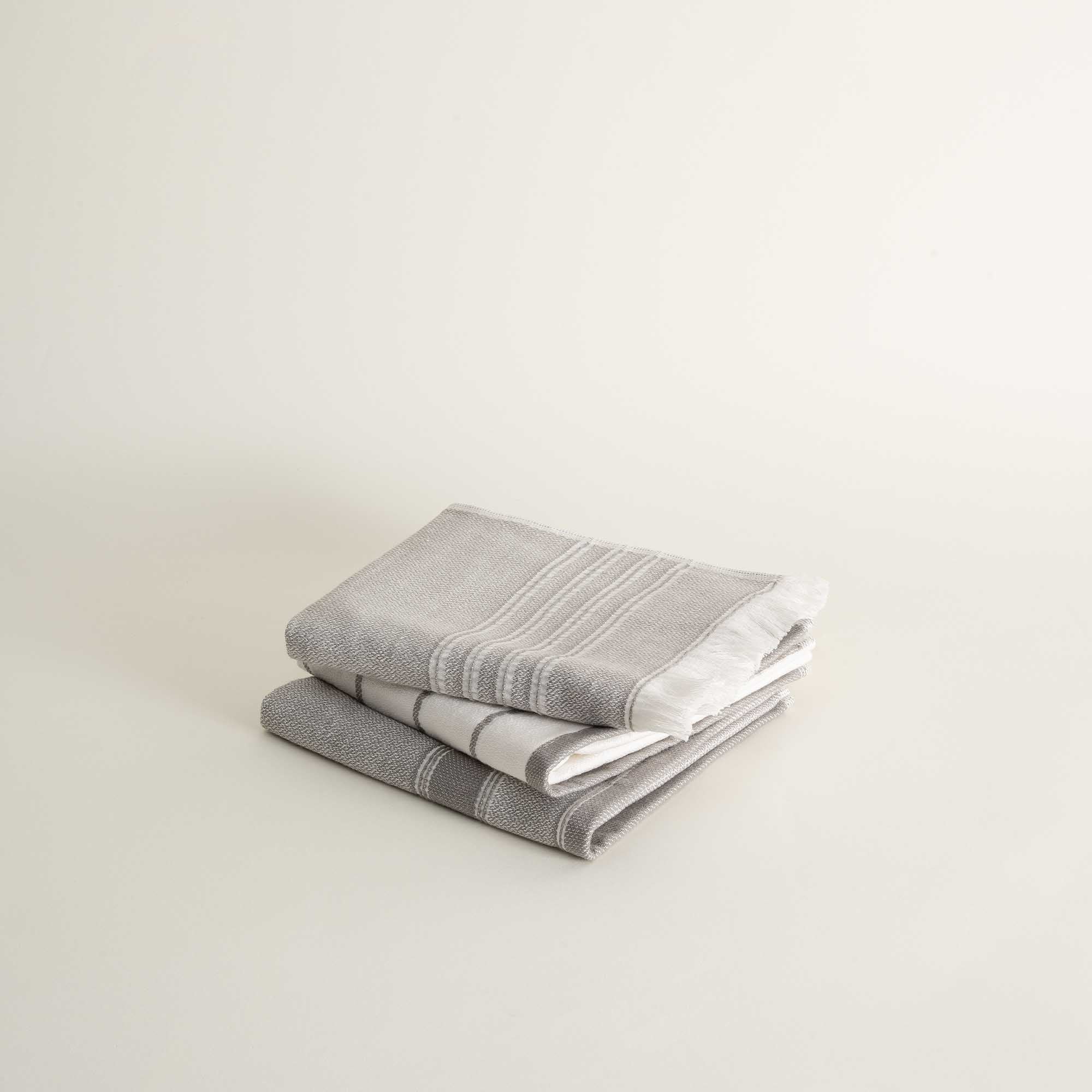 Stack of gray striped towels on a light beige background