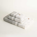 Stack of folded gray and white striped towels on a light background