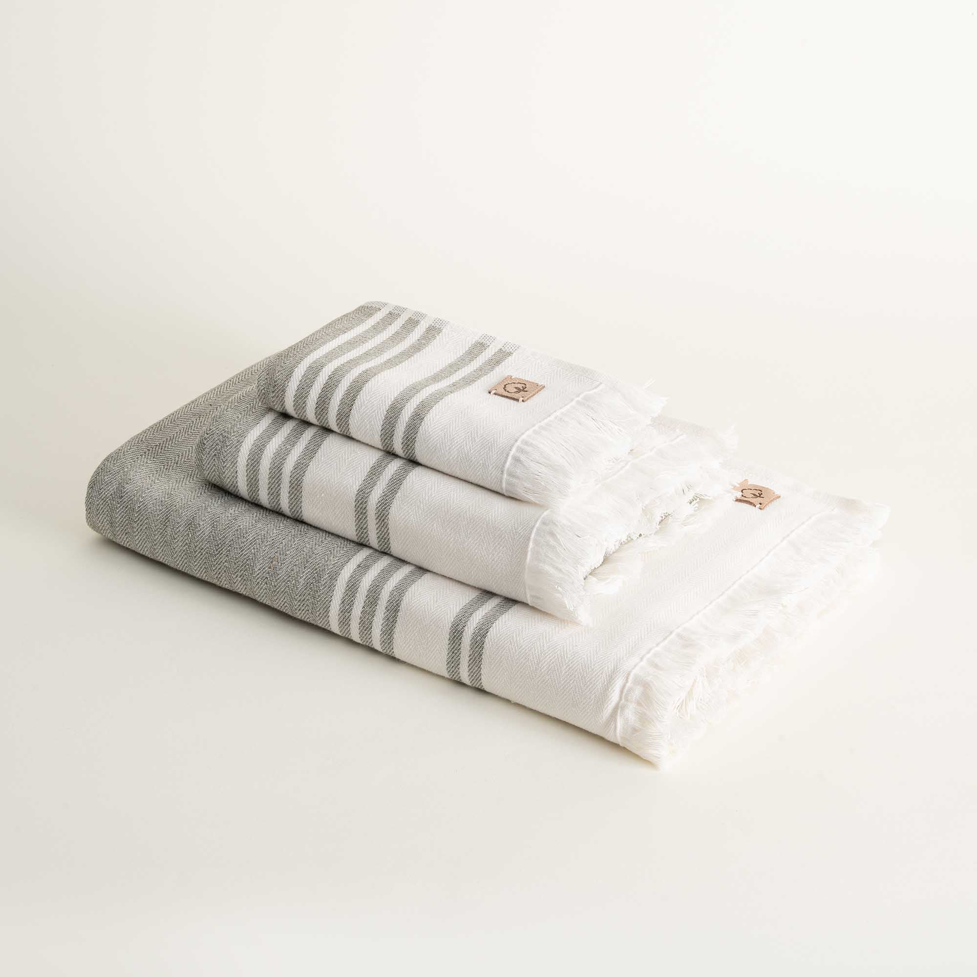 Stack of folded gray and white striped towels on a light background