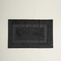 Black textured rectangular mat on a beige background