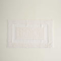 White bath mat on a light beige background