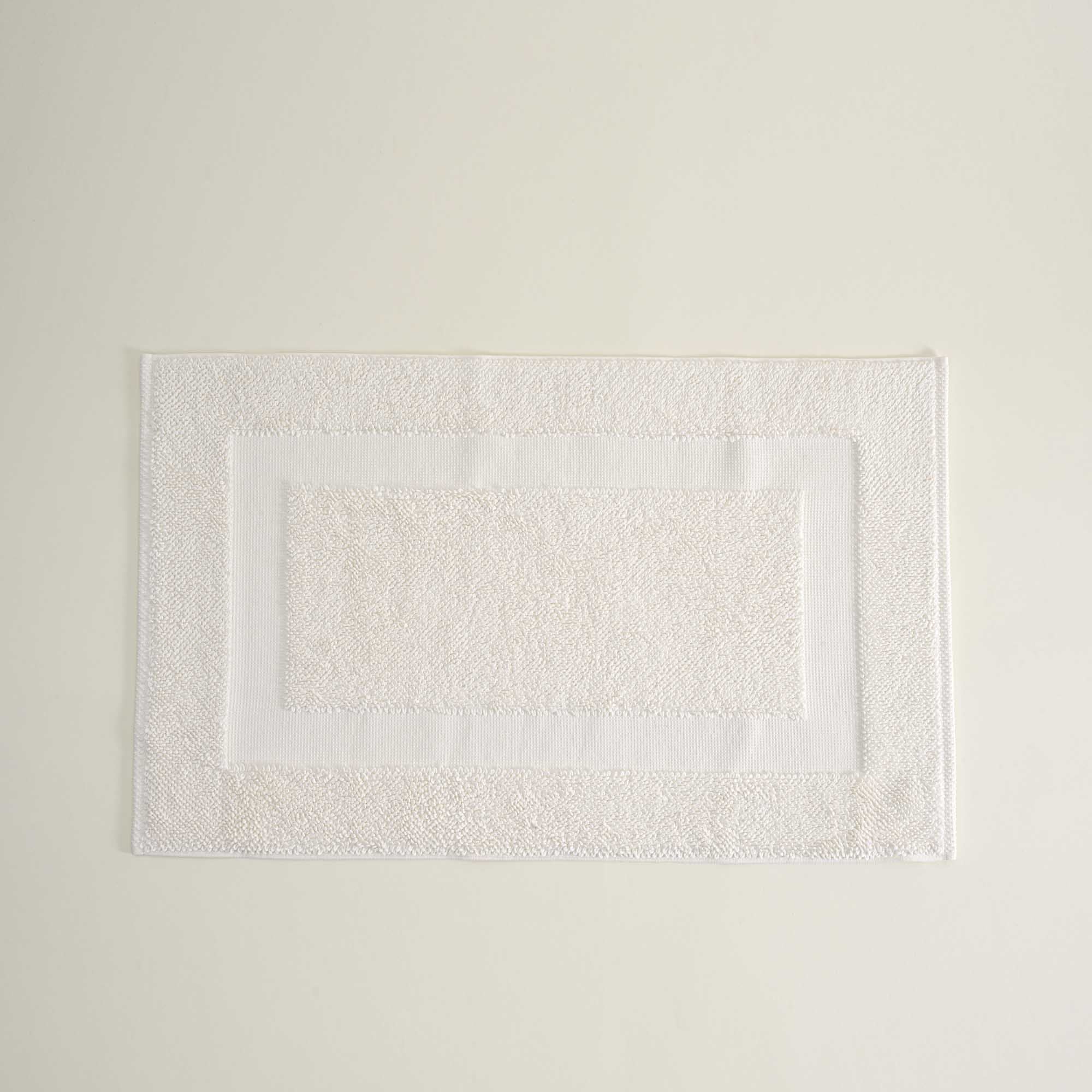Folded Kaia Aegean Cotton Bath Mat in Pearl Petal, showing its soft texture, gentle hue, and refined craftsmanship