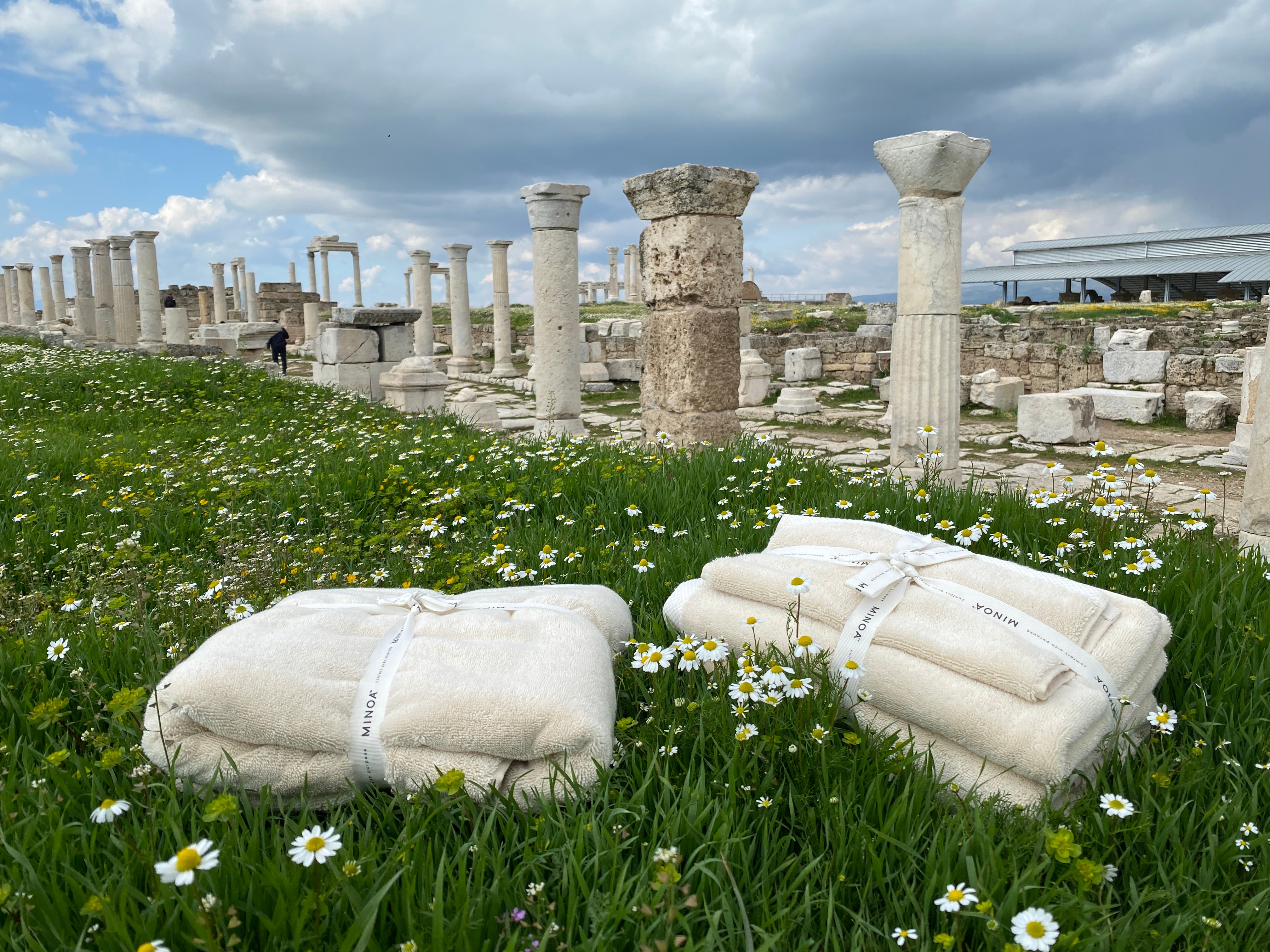 Monte Rosa towel sets bundled on a meadow in front of ruins.