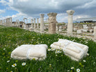 Monte Rosa towel sets bundled on a meadow in front of ruins.