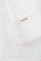 Close-up of a white towel with 'MINOA' label