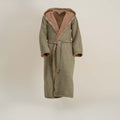 Green bathrobe with pink hood lining on a beige background