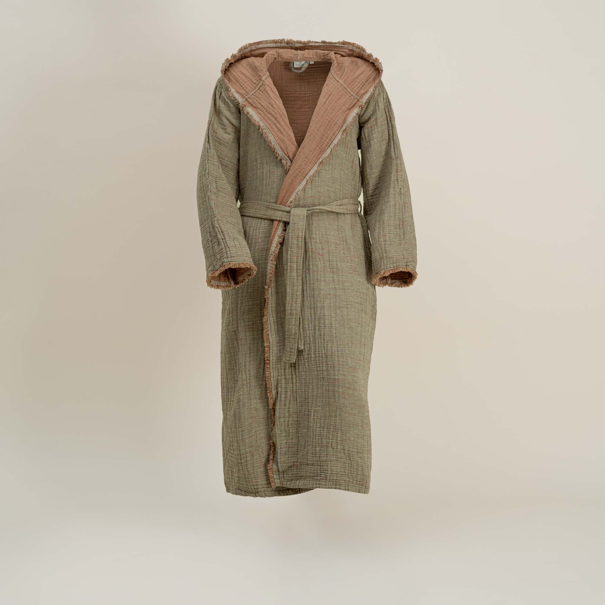 Green bathrobe with pink hood lining on a beige background